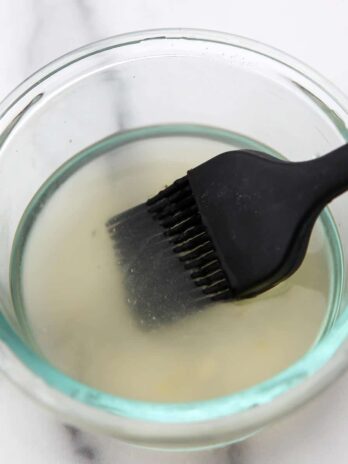 A vegan egg wash made from vegan aquafaba and agave nectar in a bowl with a pastry brush.