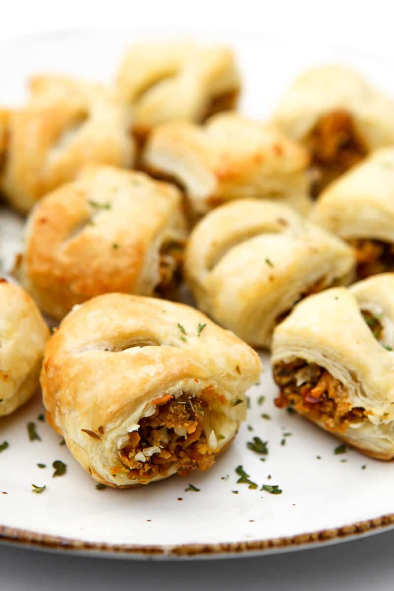 vegan sausage roll appetizers on a white plate.