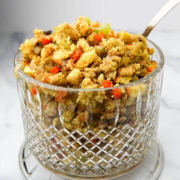 A glass bowl filled with vegan stovetop stuffing with vegetables.