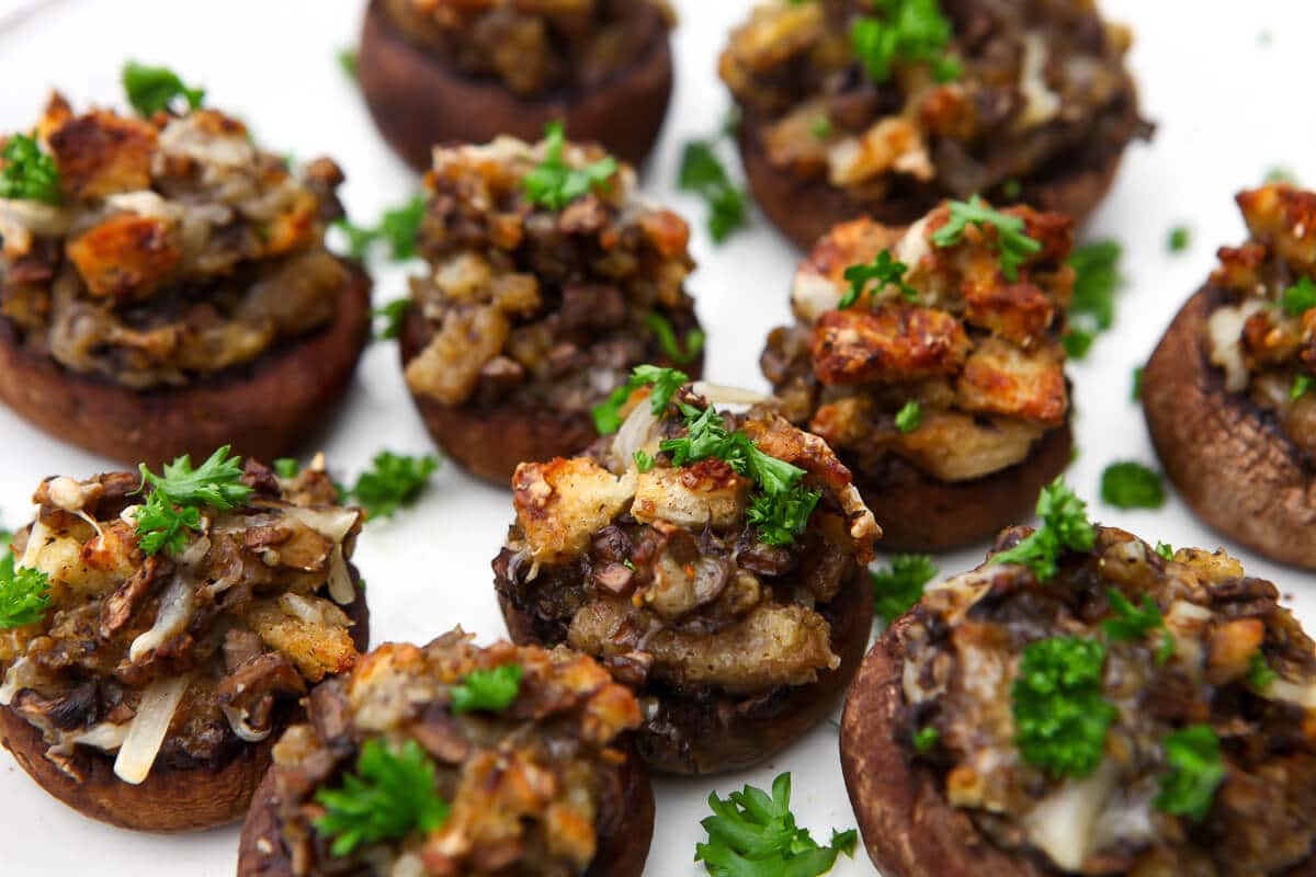 A close up of a serving dish filled with vegan stuffed mushrooms.