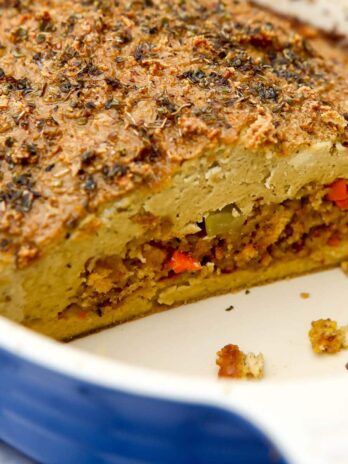 A tofu turkey roast with stuffing in the middle in a blue baking dish.