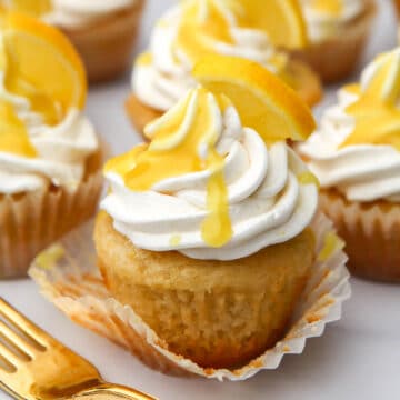 A vegan lemon cupcake with lemon curd drizzled on top.