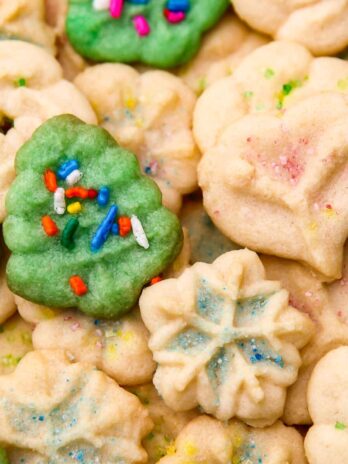 A close up of vegan spritz cookies in many shapes and colors.