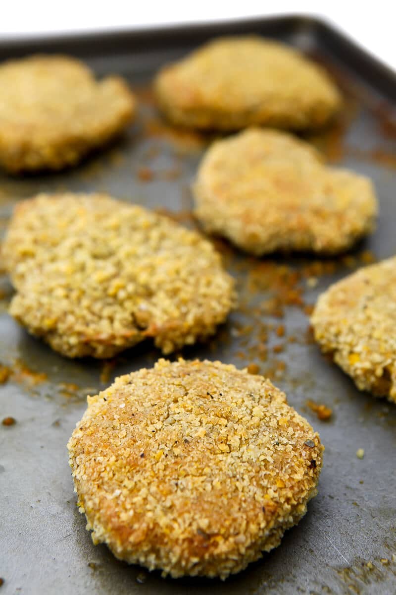 Vegan chicken patties on a baking sheet, showing the texture after baked