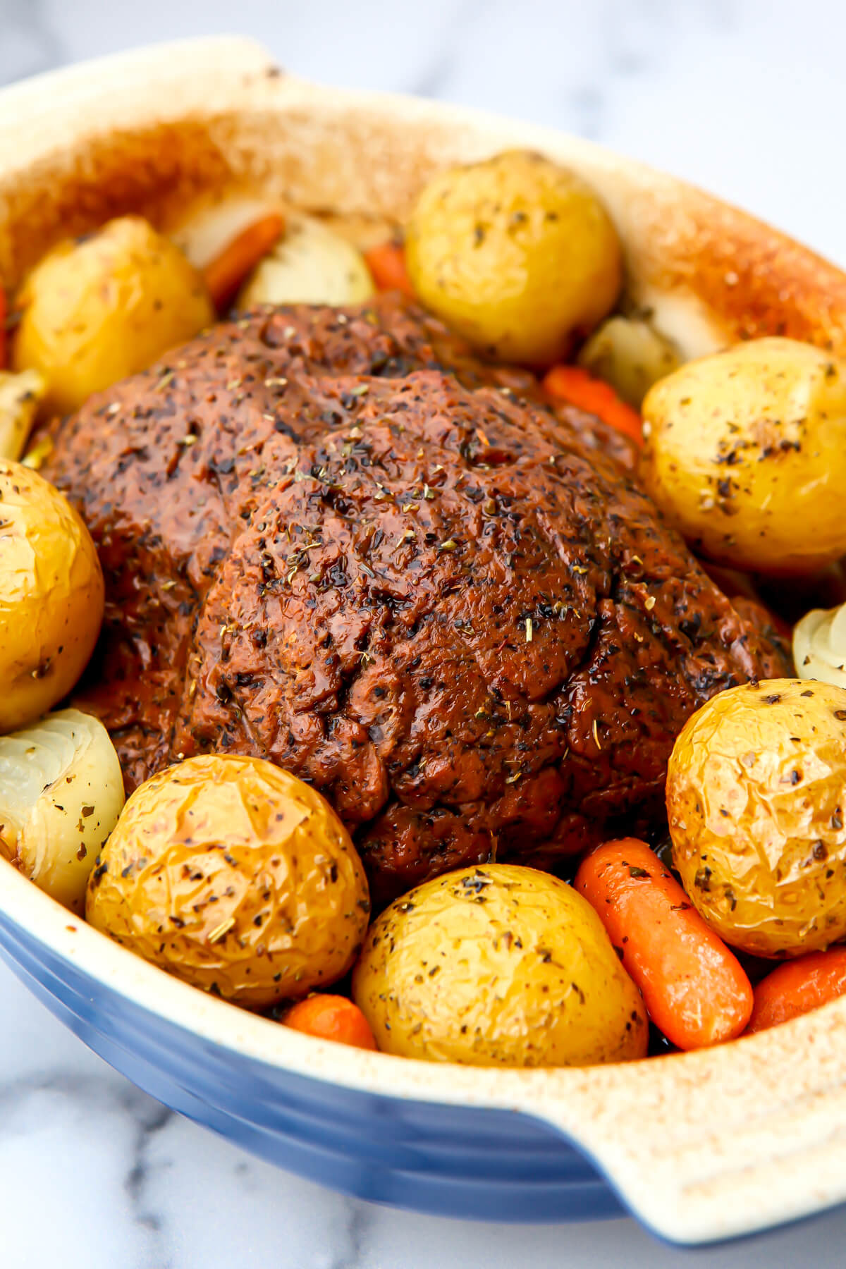A vegan pot roast made with a vegan beef loaf with potatoes, carrots, and onions.