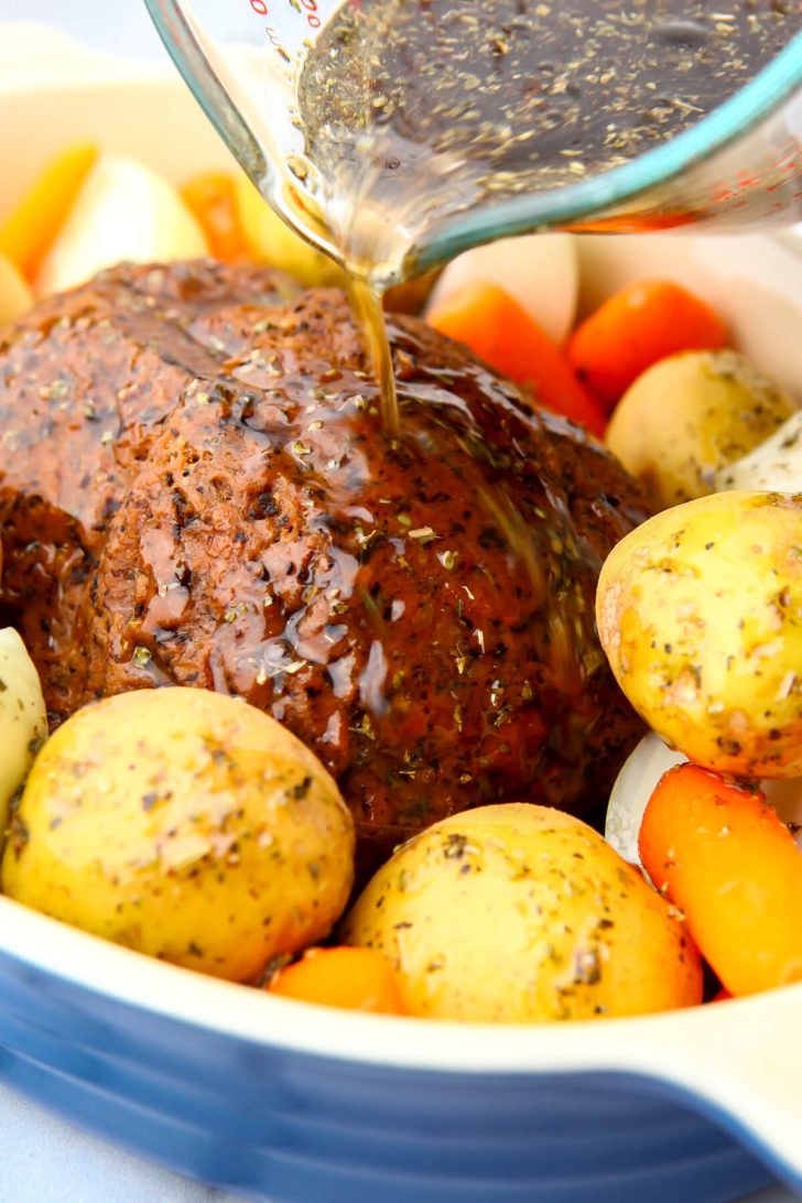 The gravy mixture being poured over the vegan pot roast.