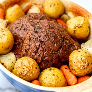 A vegan pot roast with beef seitan, potatoes and carrots baked in a casserole dish.