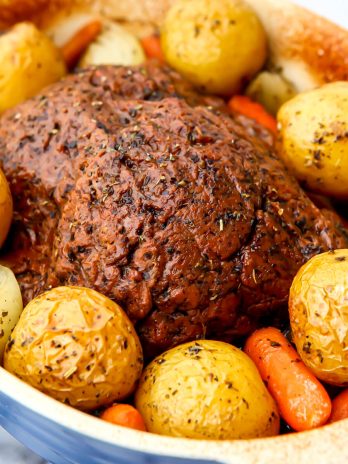 A vegan pot roast with beef seitan, potatoes and carrots baked in a casserole dish.
