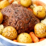 A vegan pot roast with beef seitan, potatoes and carrots baked in a caserole dish.