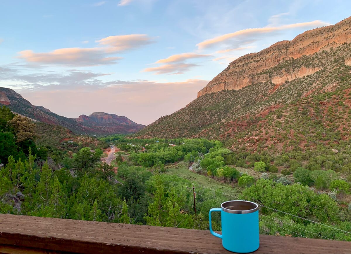 Sunrise in Jemez Springs New Mexico with a coffee cup on a deck railing.