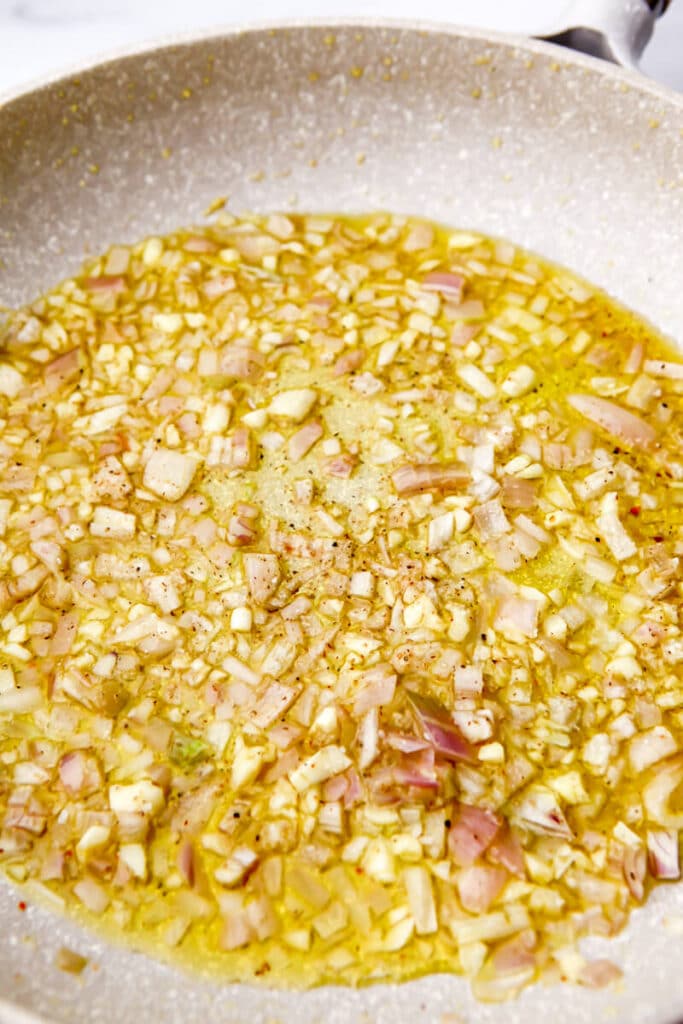 Shallots and garlic frying in olive oil.