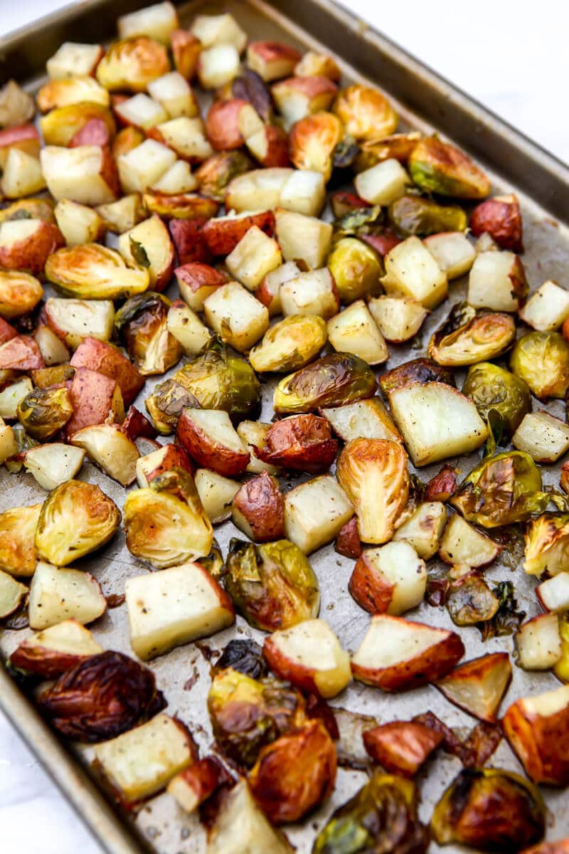 A sheet pan full or roasted red potatoes and Brussel sprouts.