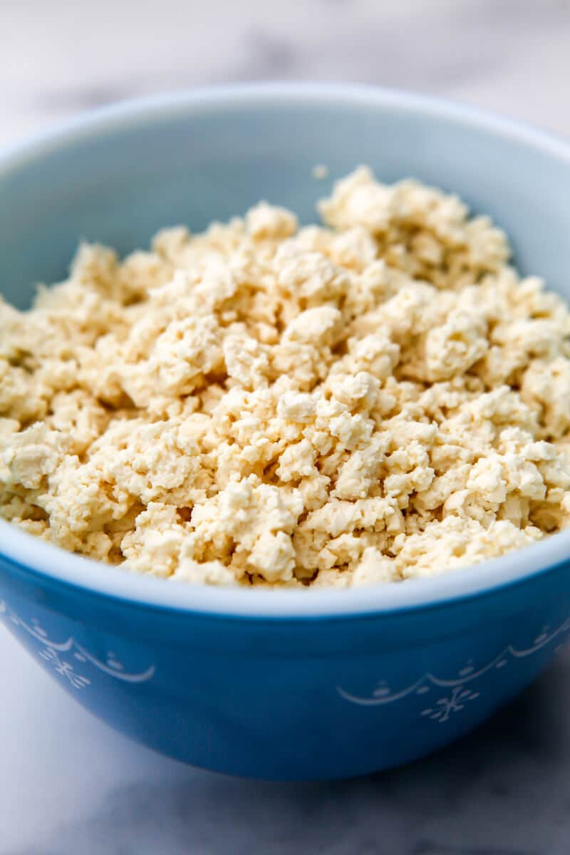 A blue bowl filled with crumbled tofu.