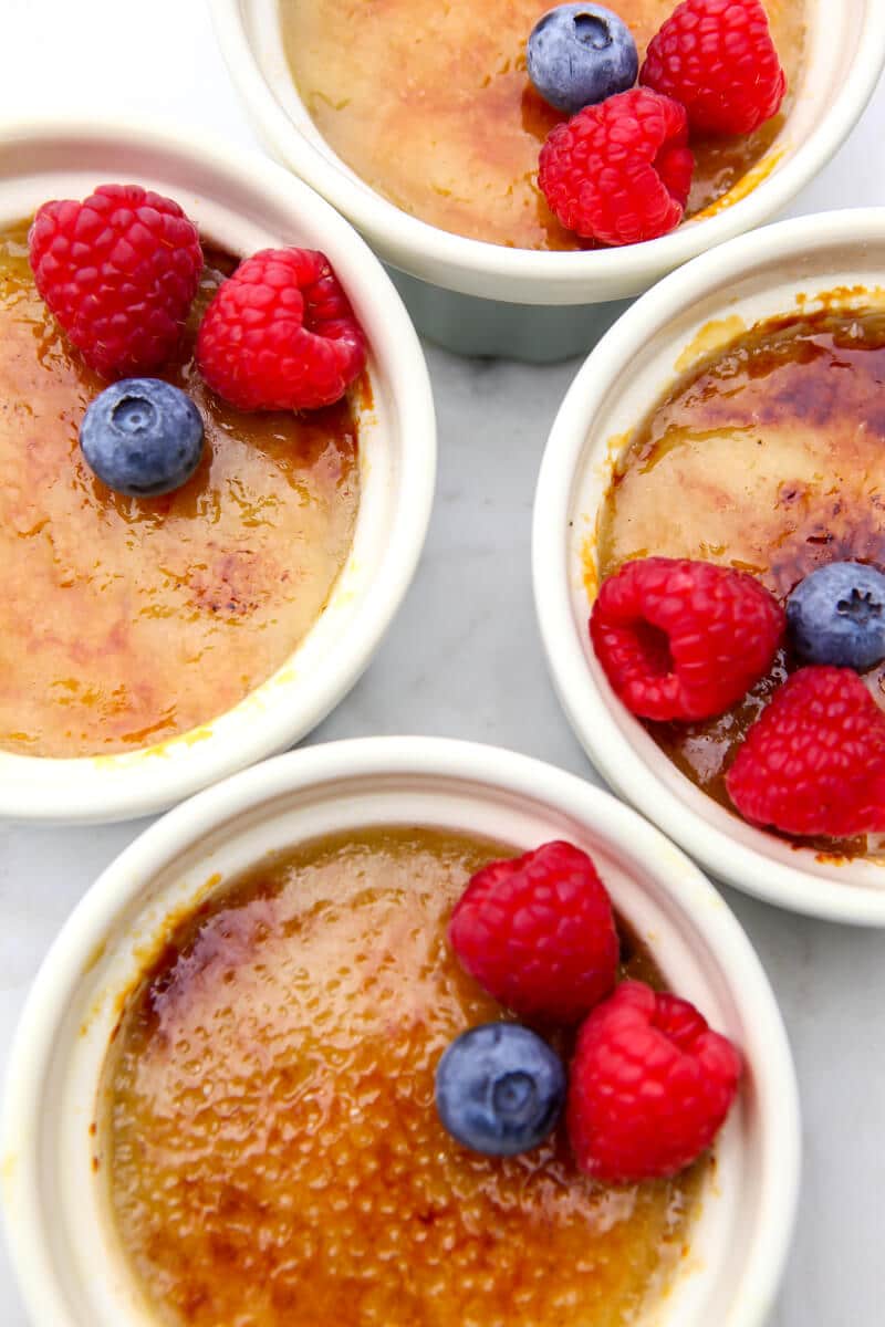 A top view of 4 remikans with vegan creme brulee and berries on top.