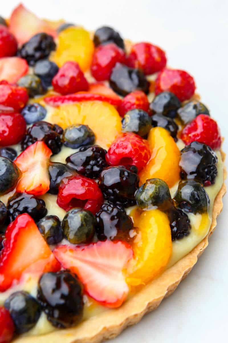 A vegan fruit tart with lemon custard, berries and apricot jelly.
