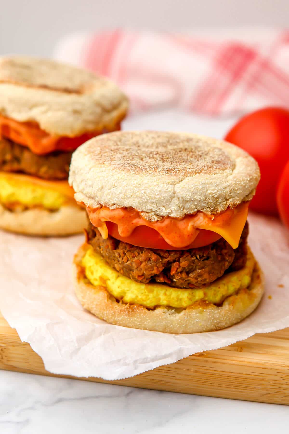 Vegan sausage McMuffins made with vegan breakfast saucesage and tofu on a cutting board.