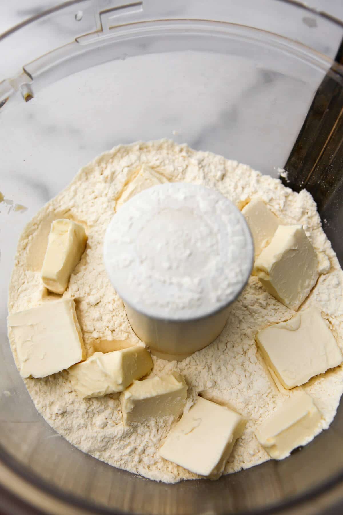 Flour, butter and salt in a food processor to make vegan emanada dough.