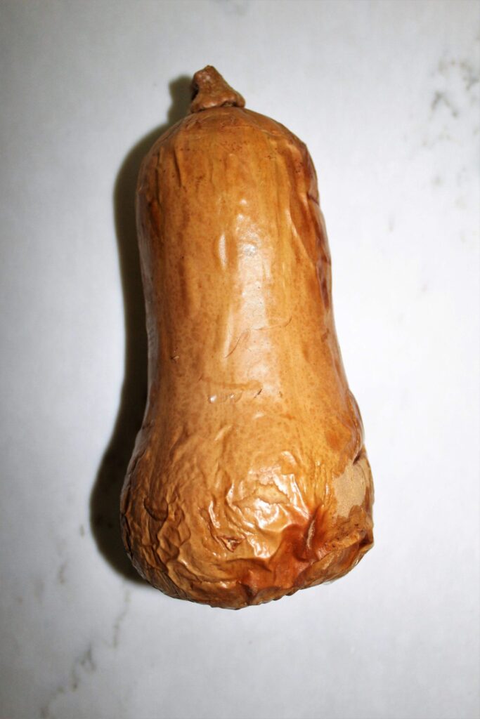 A cooked butternut squash with skin still on it.