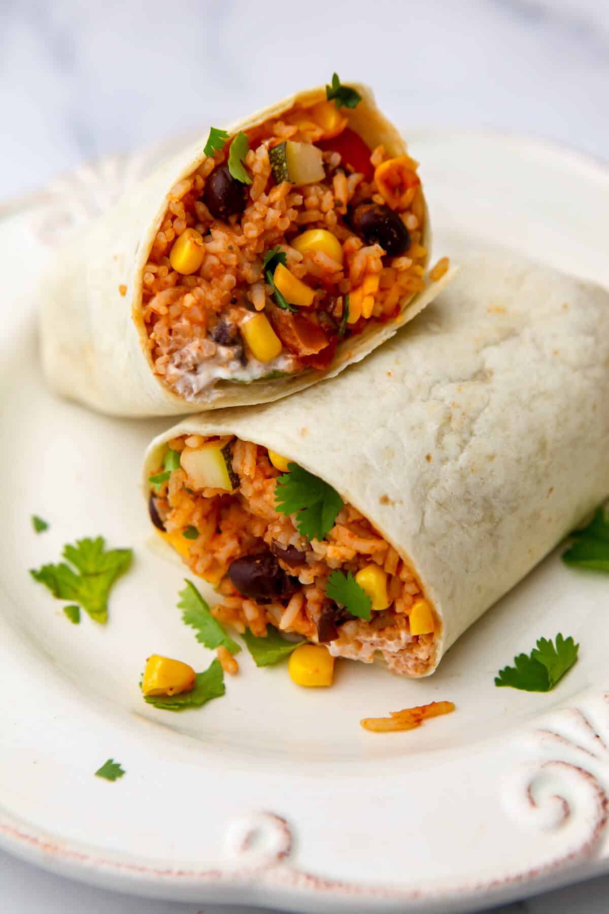Vegan burritos filled with Mexican rice, vegan sour cream, and cilantro.