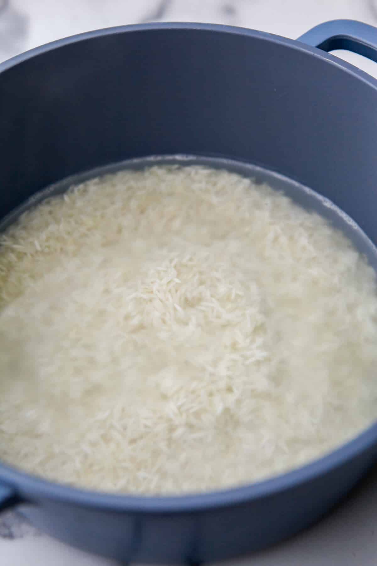 Basmati rice and water in a pot before cooking.