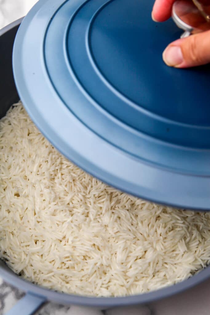A lid being taken off of cooked rice.