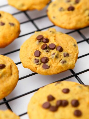 A close up of vegan chocolate chip pumpkin cookies on a cookie wrack.