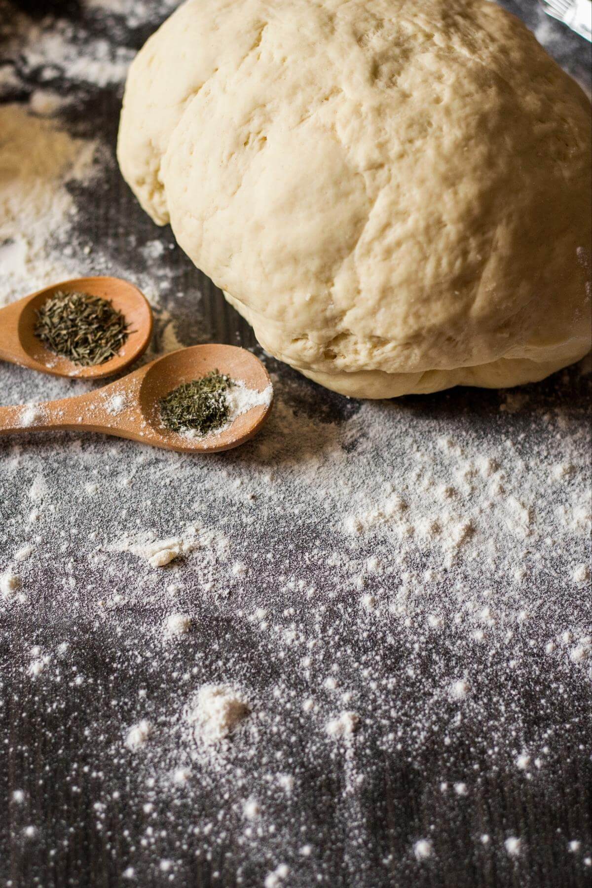 Vegan pizza dough on a floured counter top.