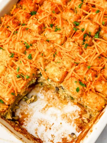 A vegan breakfast casserole topped with tater tots with a piece taken out.