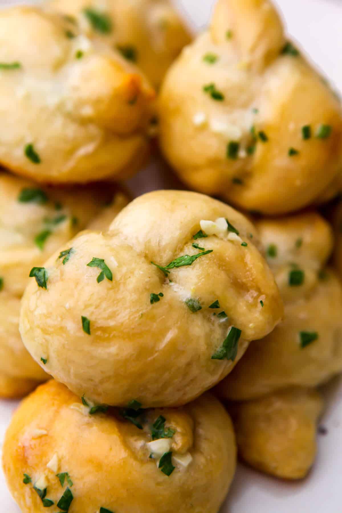 A close up of garlic knots stacked on a plate.