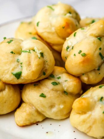 Vegan garlic knots on a white plate.