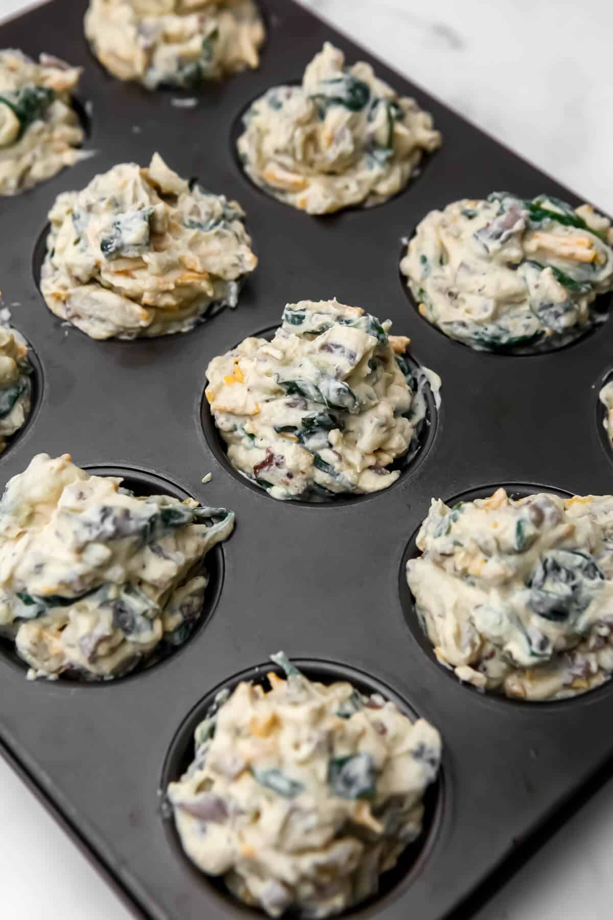 Blended tofu and veggies mixed into a batter and put in a muffin tin before baking.