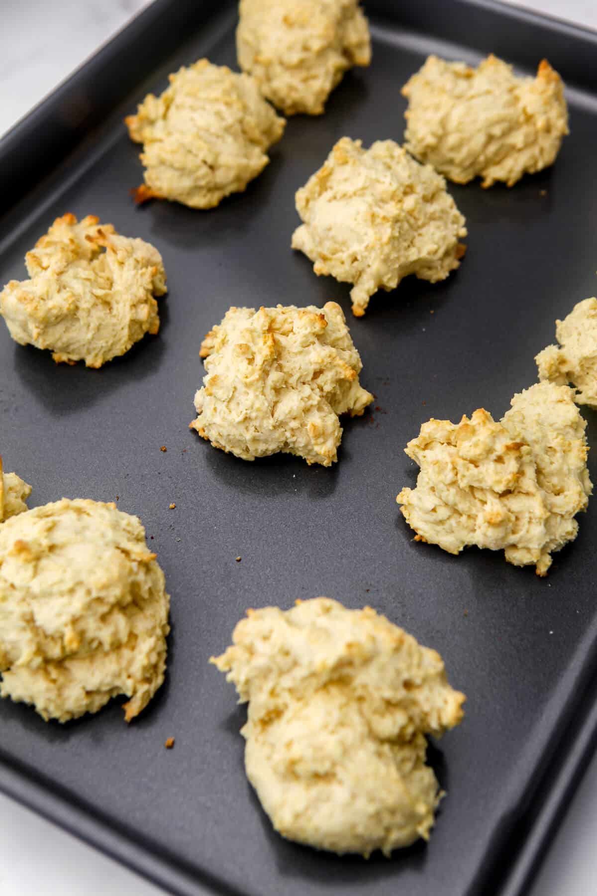 Vegan drop biscuits on a baking tray after they have been baked.