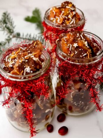 Three mason jars filled with vegan Christmas Crack with bows tied on them.