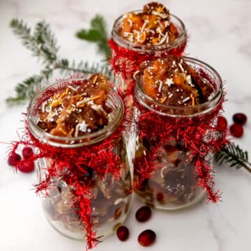 Three mason jars filled with vegan Christmas Crack with bows tied on them.