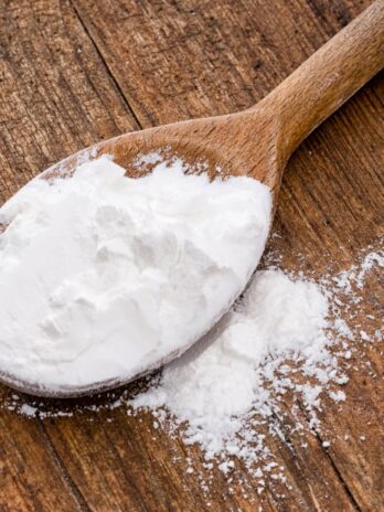 A wooden spoon full of cream of tartar powder.