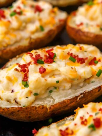 Vegan twice baked potatoes stuffed with cheesy vegan mashed potatoes and toped with bacon bits and chives.