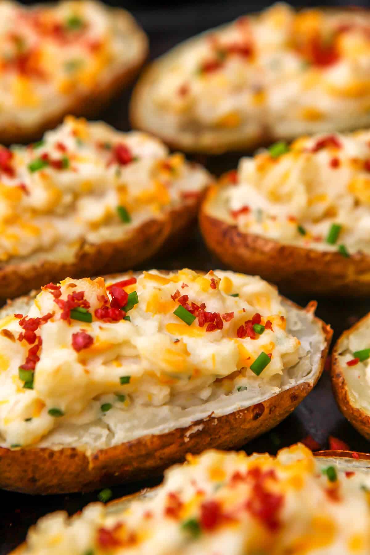 Vegan twice baked potatoes with bacon bit and chives on top.