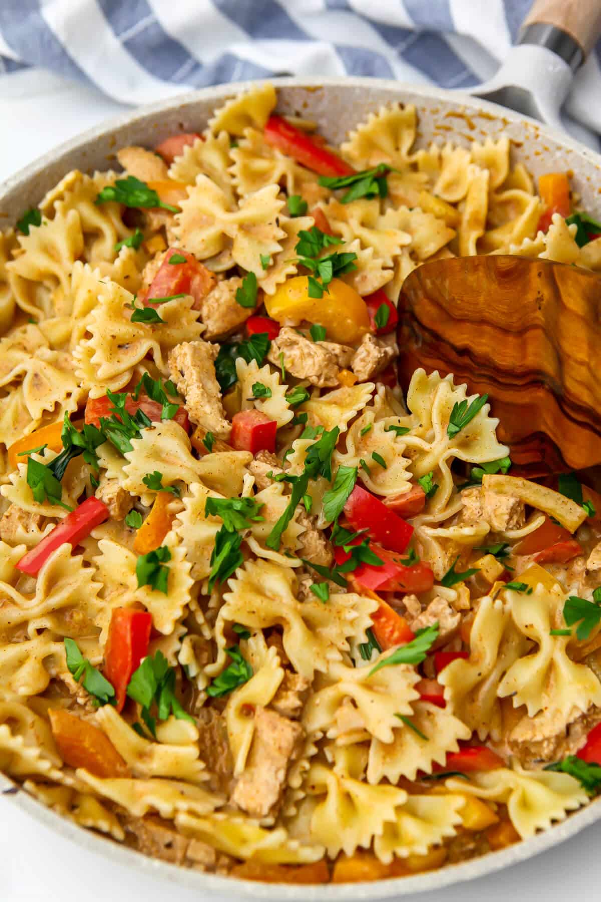Bow tie pasta cooked with colorful bell peppers and green onion in a creamy jerk sauce.