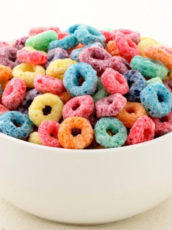 A close up of a bowl of fruit loops cereal.
