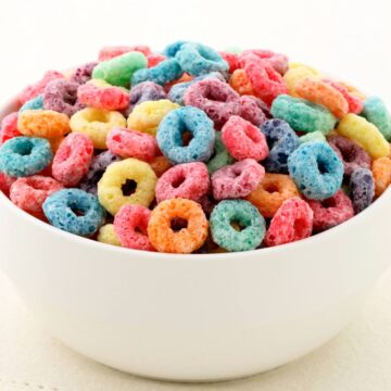 A close up of a bowl of fruit loops cereal.