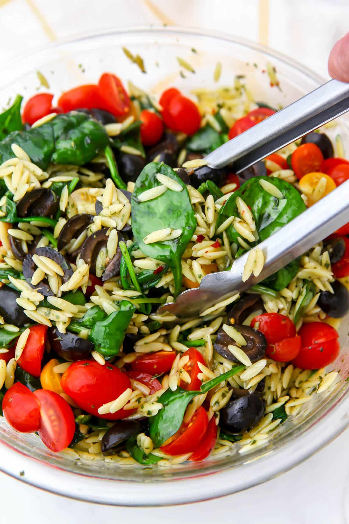 Orzo pasta mixed with vegan pesto, baby spinach, cherry tomatoes, and black olives.