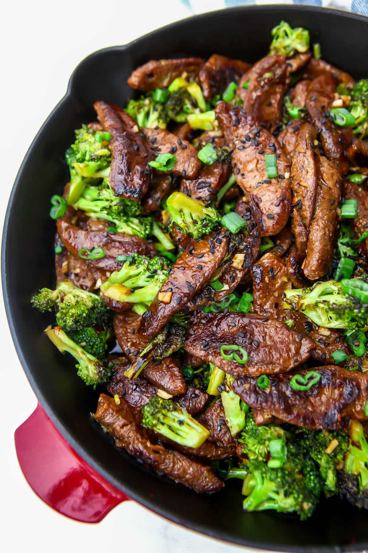 Vegan beef strips sauteing in an skillet with  broccoli.