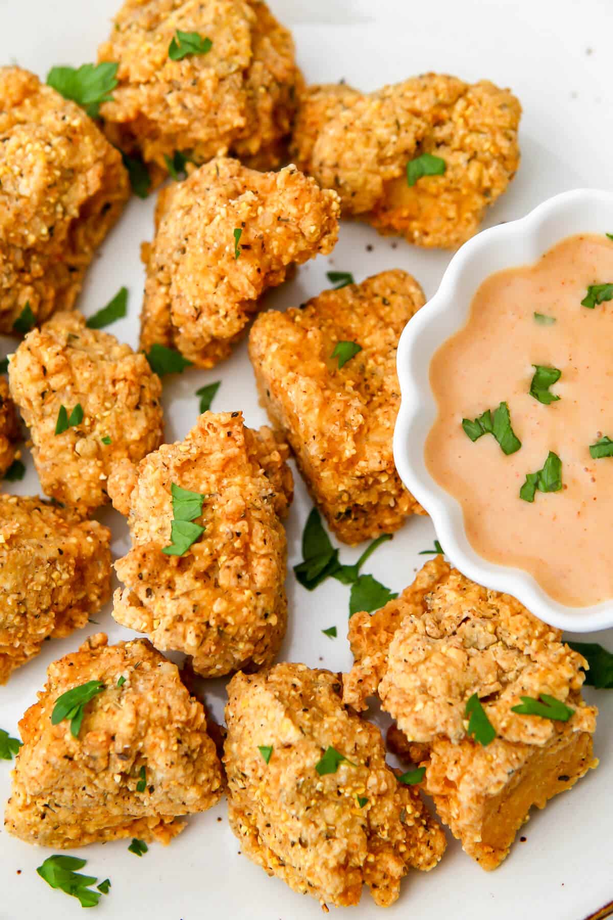 A close up of vegan chicken nuggets made from tofu with a dipping sauce on the side.