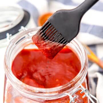 Vegan bbq sauce in a jar with sauce on a brush.