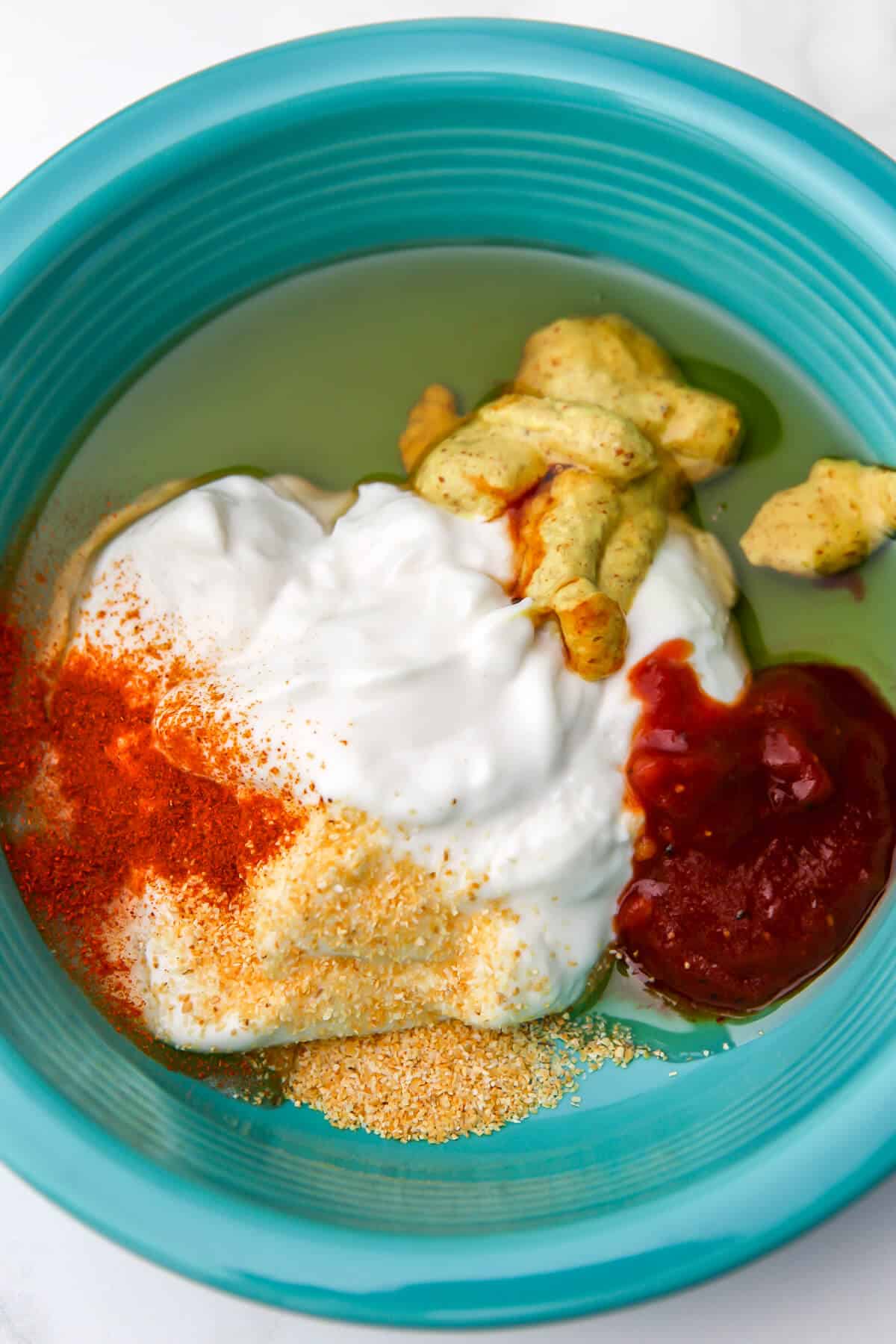 Vegan mayo, mustard, BBQ sauce, agave, garlic powder, and paprika in a bowl before mixing into vegan chick fil a sauce.
