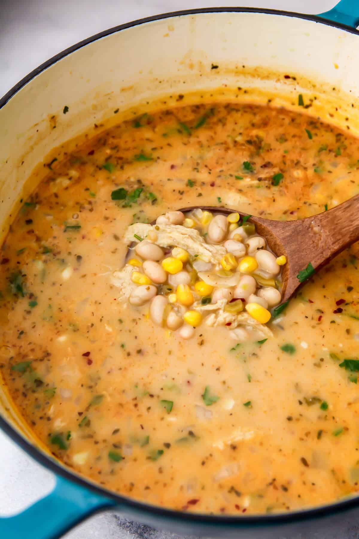A pot of vegan white chili with vegan chicken, white beans and corn.