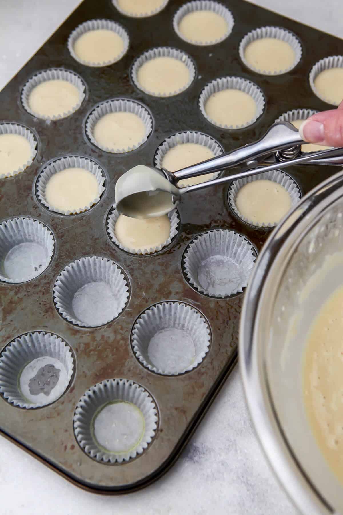 Filling mini cupcake liners with a cookie scoop.