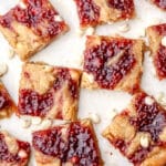 Vegan white chocolate raspberry blondies cut into squares on a countertop.