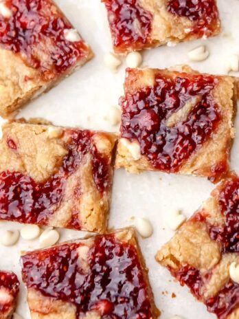 Vegan white chocolate raspberry blondies cut into squares on a countertop.