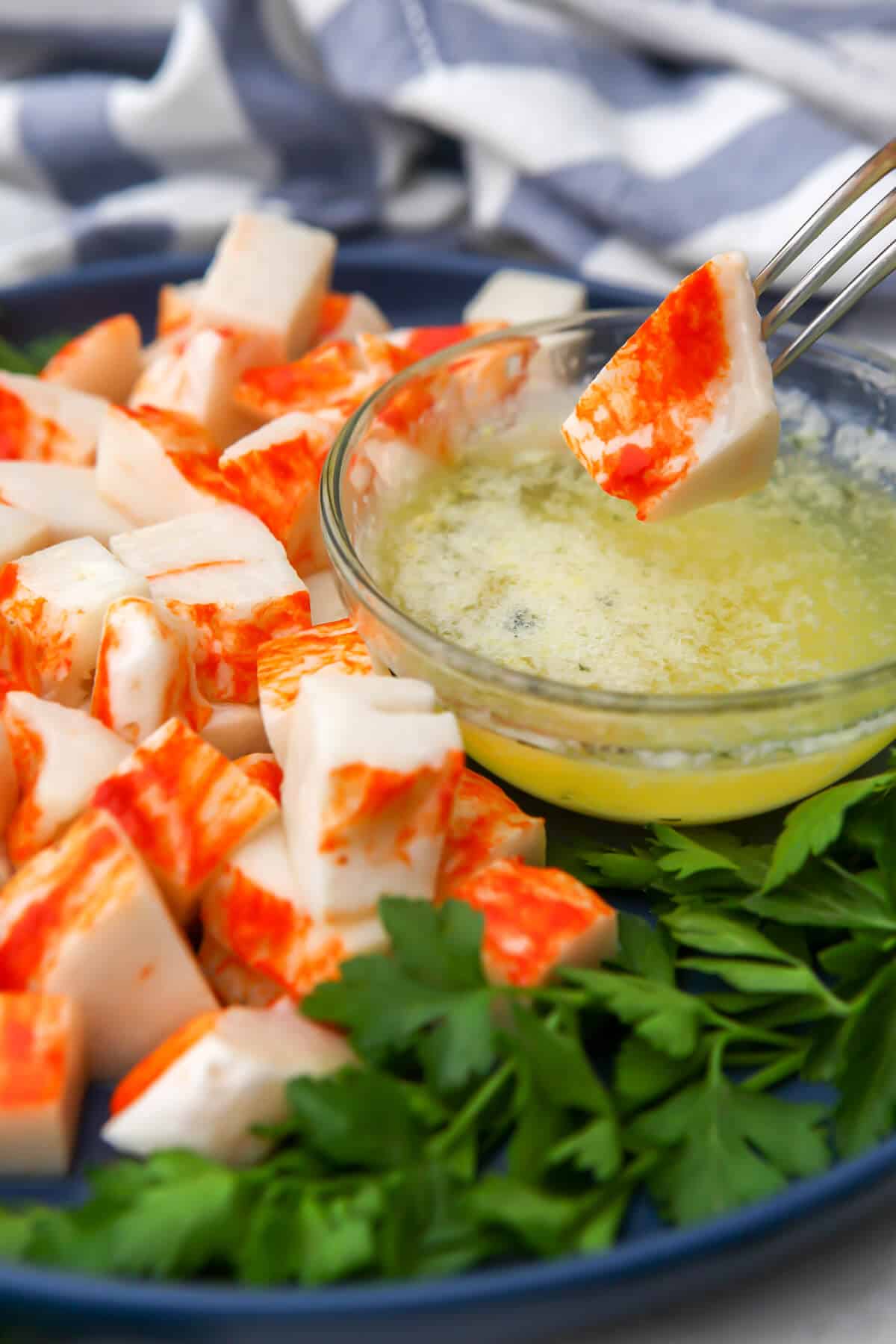 Vegan lobster being dipped into melted butter.
